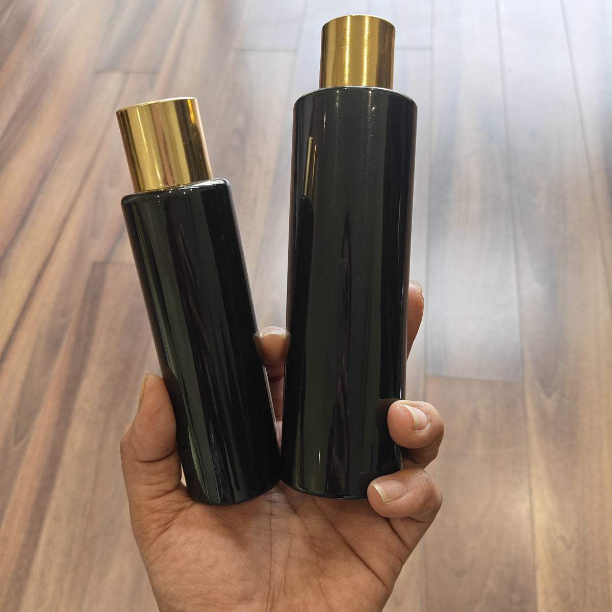 100ml–200ml Sleek Cylinder Black Bottle with Gold Screw Cap | Cosmetic Packaging